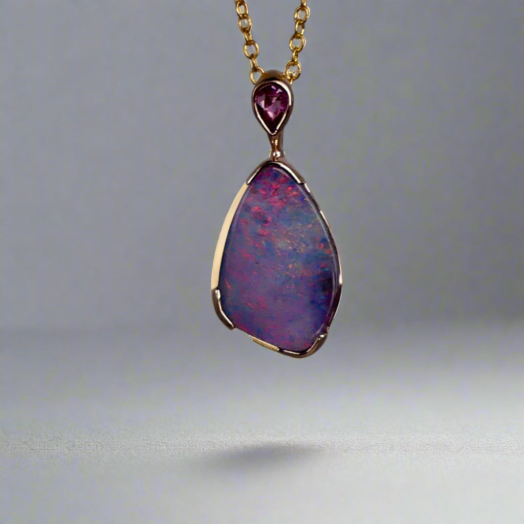 Add a touch of elegance to your jewelry collection with this stunning 9k gold Australian boulder opal pendant. The mesmerizing colors of the opal create a unique and beautiful piece that will surely turn heads. Perfect for everyday wear or special occasions, this pendant is a must-have for any opal lover. A timeless accessory that will elevate any outfit effortlessly.

Opal- 6.75ct Australian Boulder Opal

Origin- Queensland Australia

Setting- 9k Gold Bezel Set

Accent Stone- Pink Sapphire

