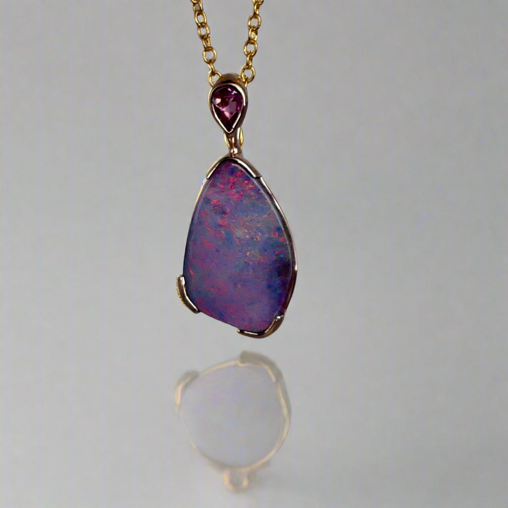 Add a touch of elegance to your jewelry collection with this stunning 9k gold Australian boulder opal pendant. The mesmerizing colors of the opal create a unique and beautiful piece that will surely turn heads. Perfect for everyday wear or special occasions, this pendant is a must-have for any opal lover. A timeless accessory that will elevate any outfit effortlessly.

Opal- 6.75ct Australian Boulder Opal

Origin- Queensland Australia

Setting- 9k Gold Bezel Set

Accent Stone- Pink Sapphire

