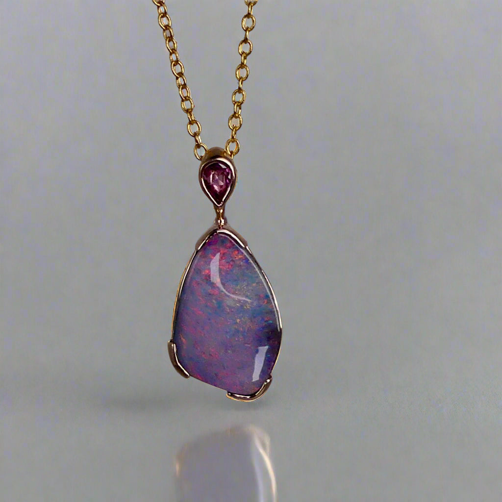 Add a touch of elegance to your jewelry collection with this stunning 9k gold Australian boulder opal pendant. The mesmerizing colors of the opal create a unique and beautiful piece that will surely turn heads. Perfect for everyday wear or special occasions, this pendant is a must-have for any opal lover. A timeless accessory that will elevate any outfit effortlessly.

Opal- 6.75ct Australian Boulder Opal

Origin- Queensland Australia

Setting- 9k Gold Bezel Set

Accent Stone- Pink Sapphire
