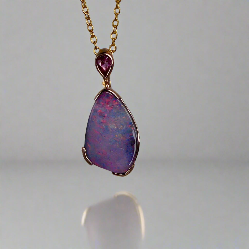 Add a touch of elegance to your jewelry collection with this stunning 9k gold Australian boulder opal pendant. The mesmerizing colors of the opal create a unique and beautiful piece that will surely turn heads. Perfect for everyday wear or special occasions, this pendant is a must-have for any opal lover. A timeless accessory that will elevate any outfit effortlessly.

Opal- 6.75ct Australian Boulder Opal

Origin- Queensland Australia

Setting- 9k Gold Bezel Set

Accent Stone- Pink Sapphire
