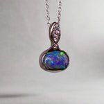 This exquisite pendant features a rare Australian Boulder Opal set in 18k white gold, expertly crafted to highlight the opal’s vibrant play of colors. Accented with natural diamonds, this statement piece that combines exceptional craftsmanship with the distinctive allure of genuine opal.