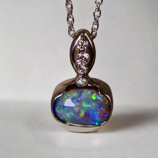 This exquisite pendant features a rare Australian Boulder Opal set in 18k white gold, expertly crafted to highlight the opal’s vibrant play of colors. Accented with natural diamonds, this statement piece that combines exceptional craftsmanship with the distinctive allure of genuine opal.