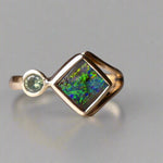 Discover the elegance of this unique 9k gold Australian Boulder Opal ring, beautifully paired with a stunning Australian sapphire. The vibrant opal’s natural patterns and the sapphire’s green blue hues create a captivating contrast, making this ring a true statement piece.