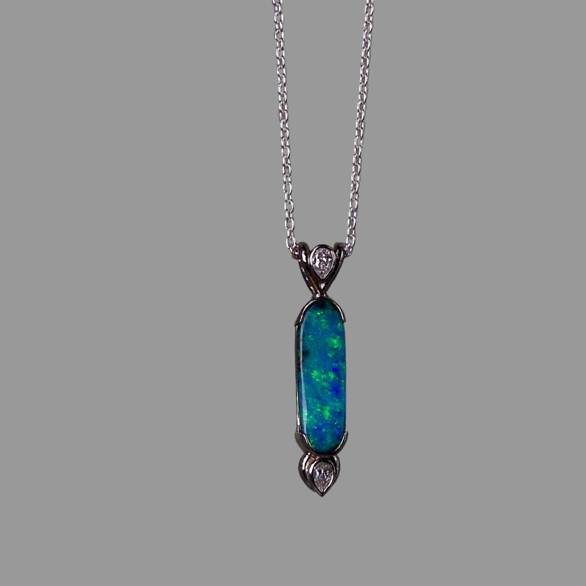 Opal pendant necklace with chain on a gray background