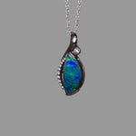 Opal pendant necklace on a gray background