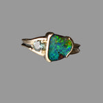 Gold ring with a large opal stone on a gray background