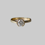 Gold ring with a diamond on a gray background