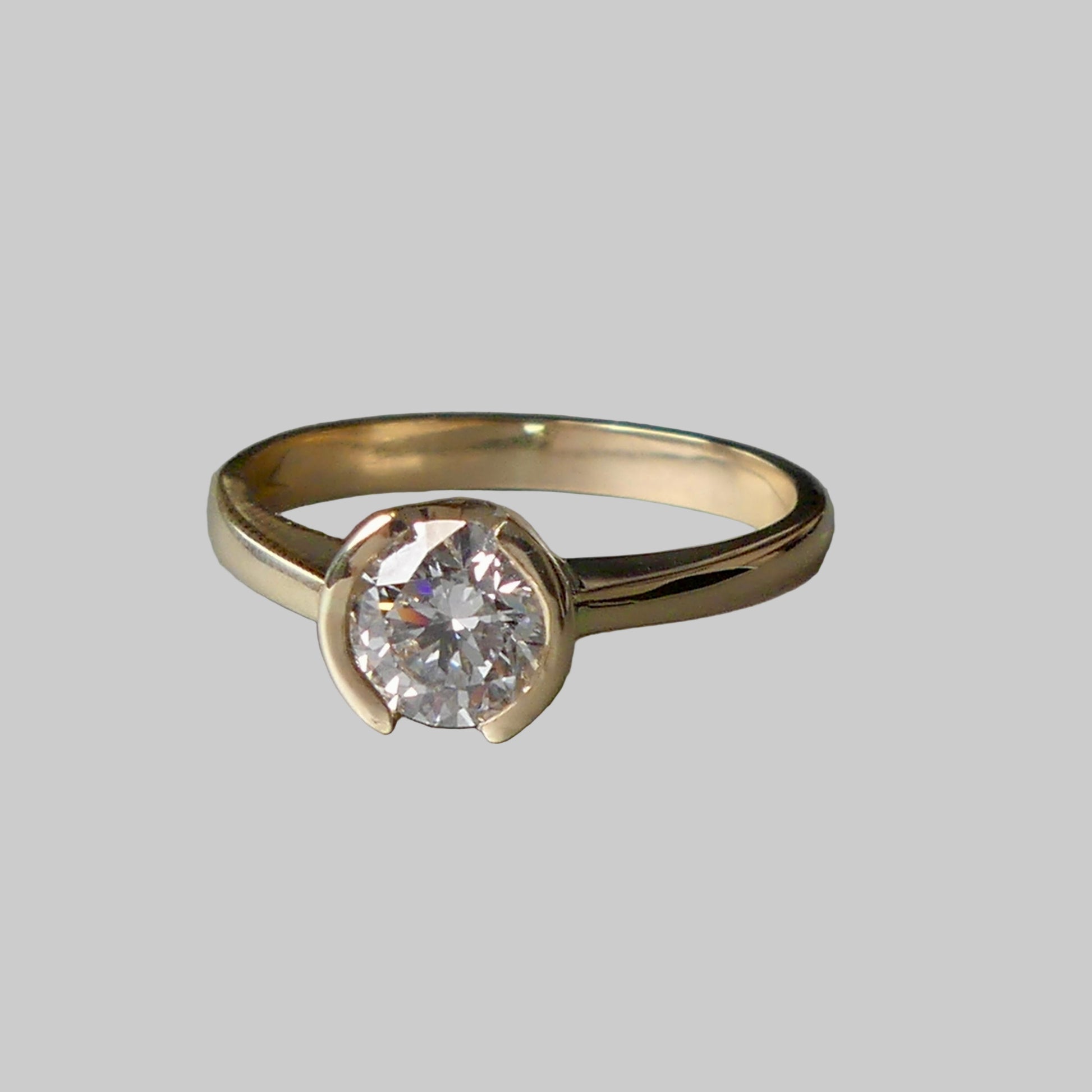 Gold ring with a diamond on a gray background