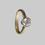 Gold ring with a diamond on a gray background
