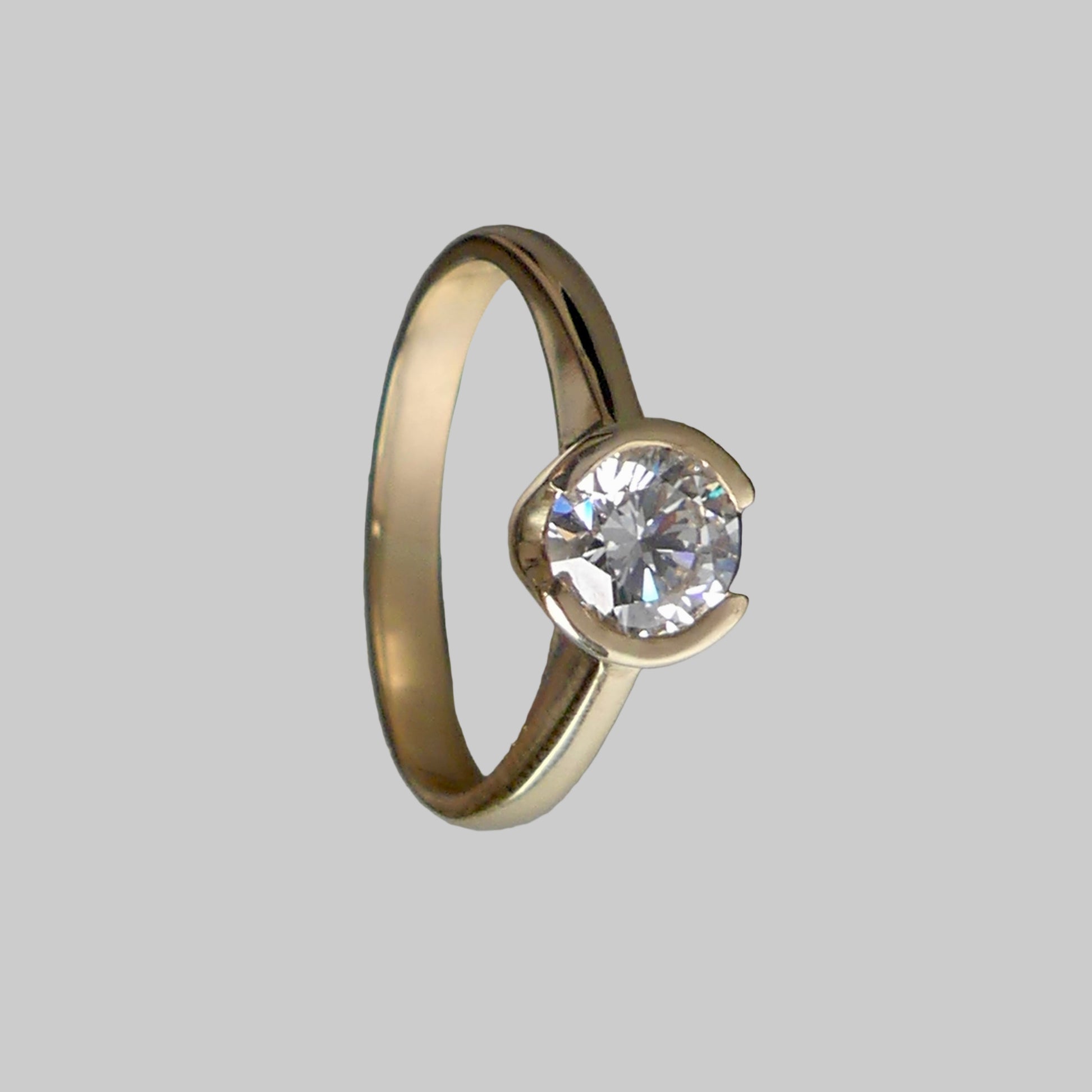 Gold ring with a diamond on a gray background