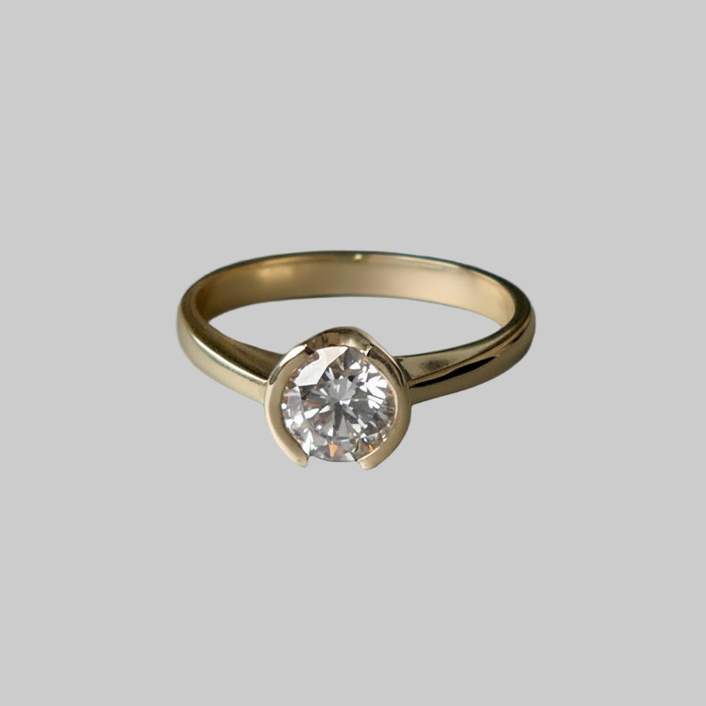 Gold ring with a diamond on a gray background