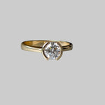 Gold ring with a diamond on a gray background