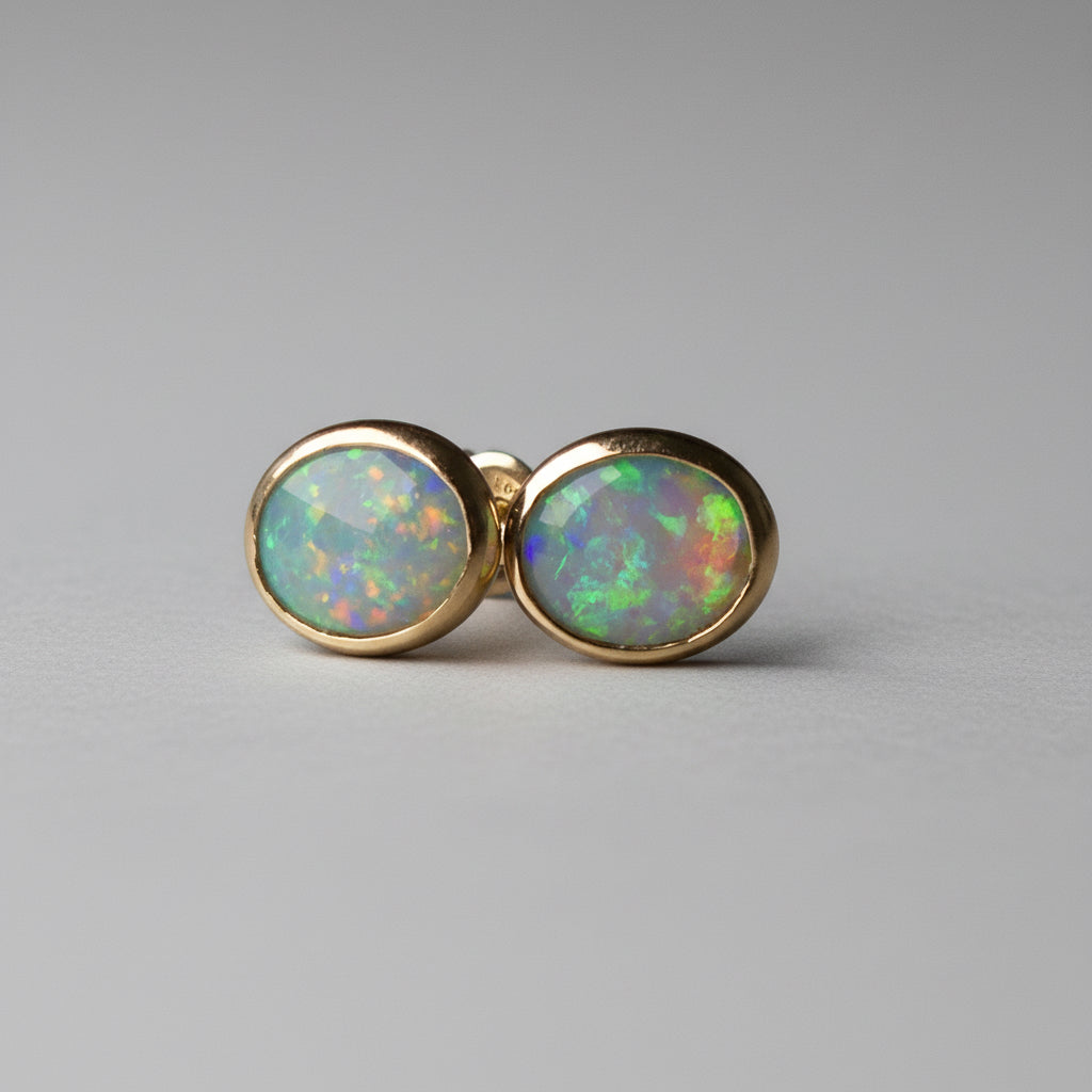 Pair of opal stud earrings on a dark gray background