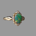 Gold ring with an opal stone on a gray background