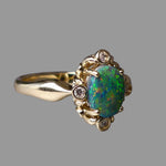 Gold ring with an opal stone and small diamonds on a gray background