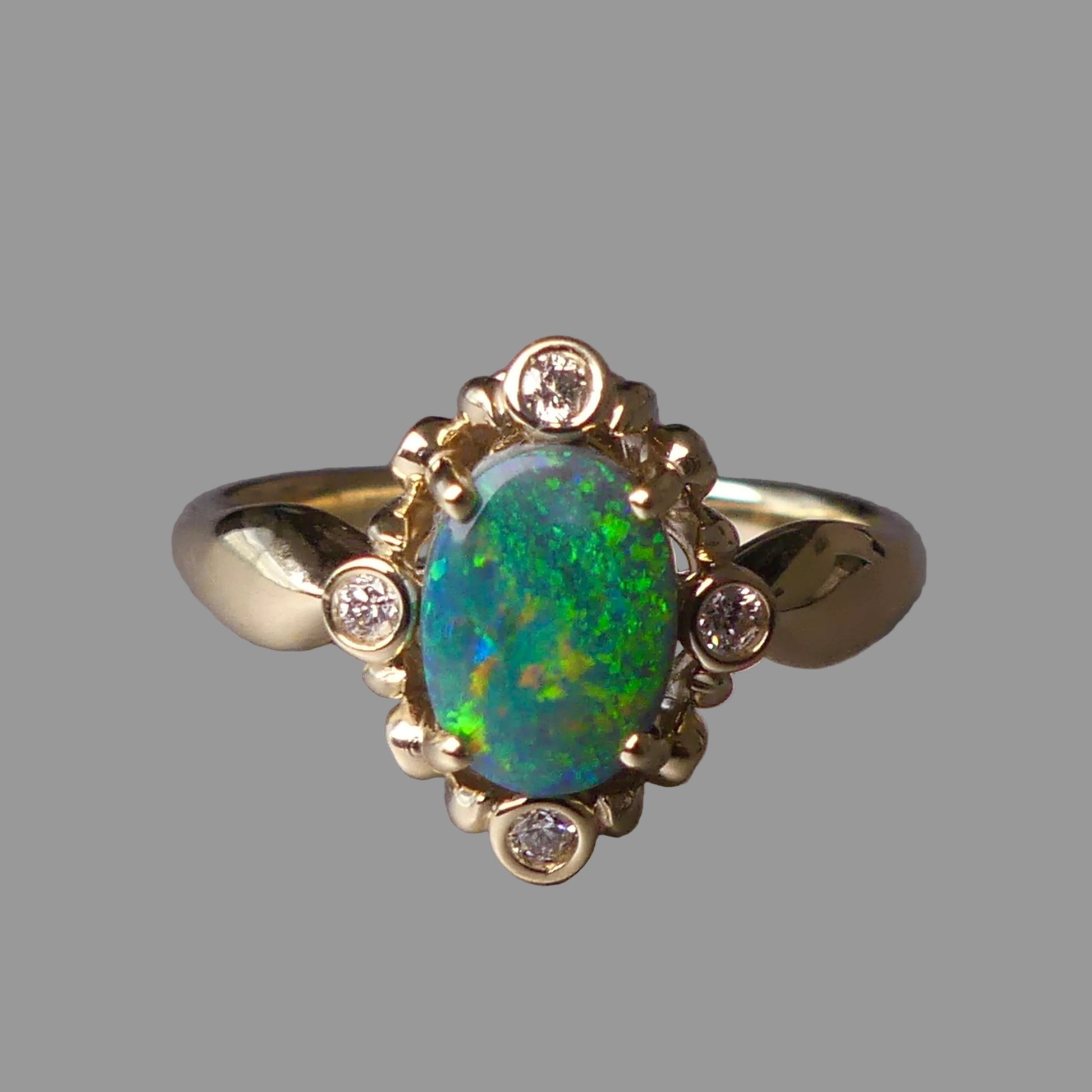 Gold ring with an opal stone on a gray background