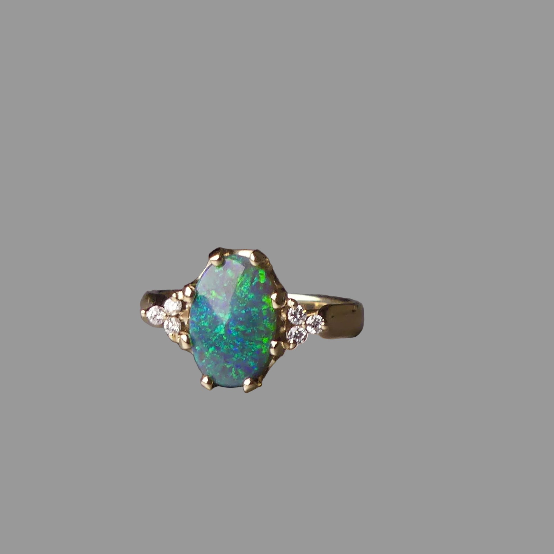 Ring with an opal stone on a gray surface