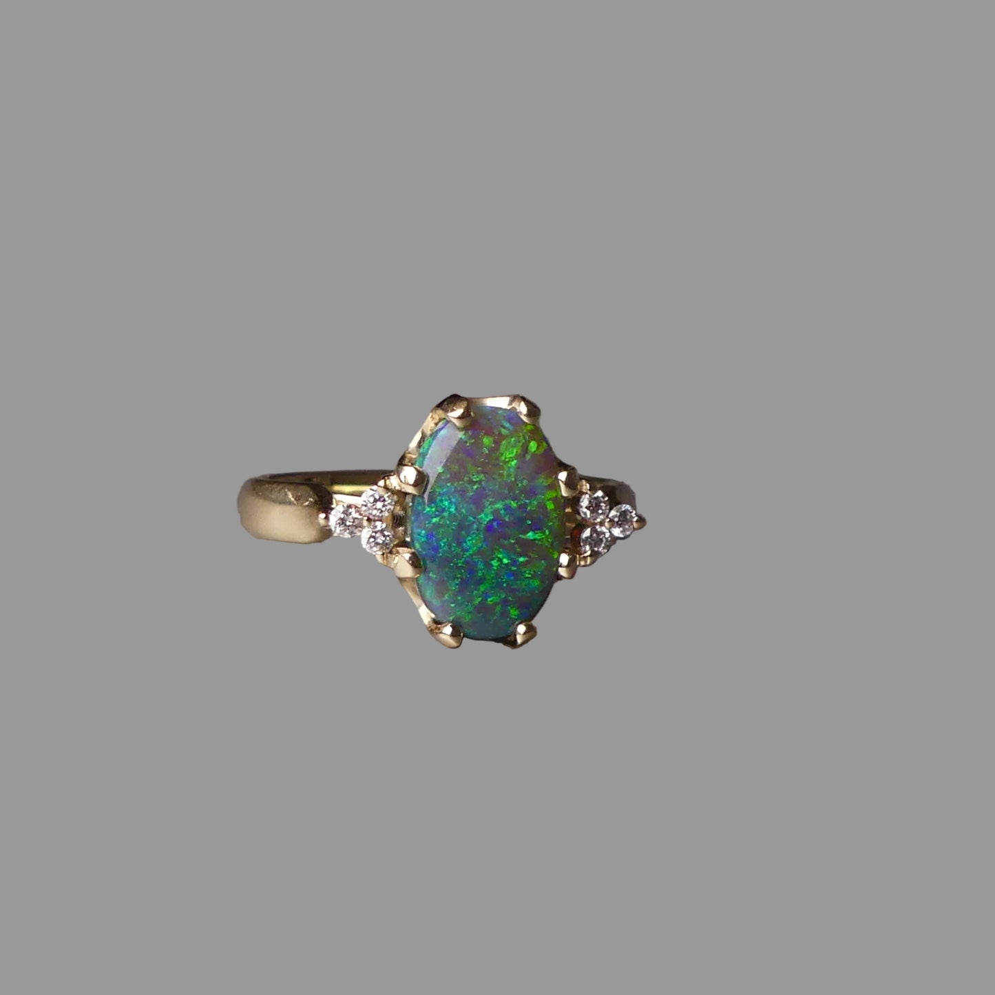 Ring with a colorful gemstone on a gray surface