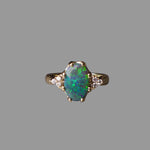 Gold ring with an opal stone on a gray background