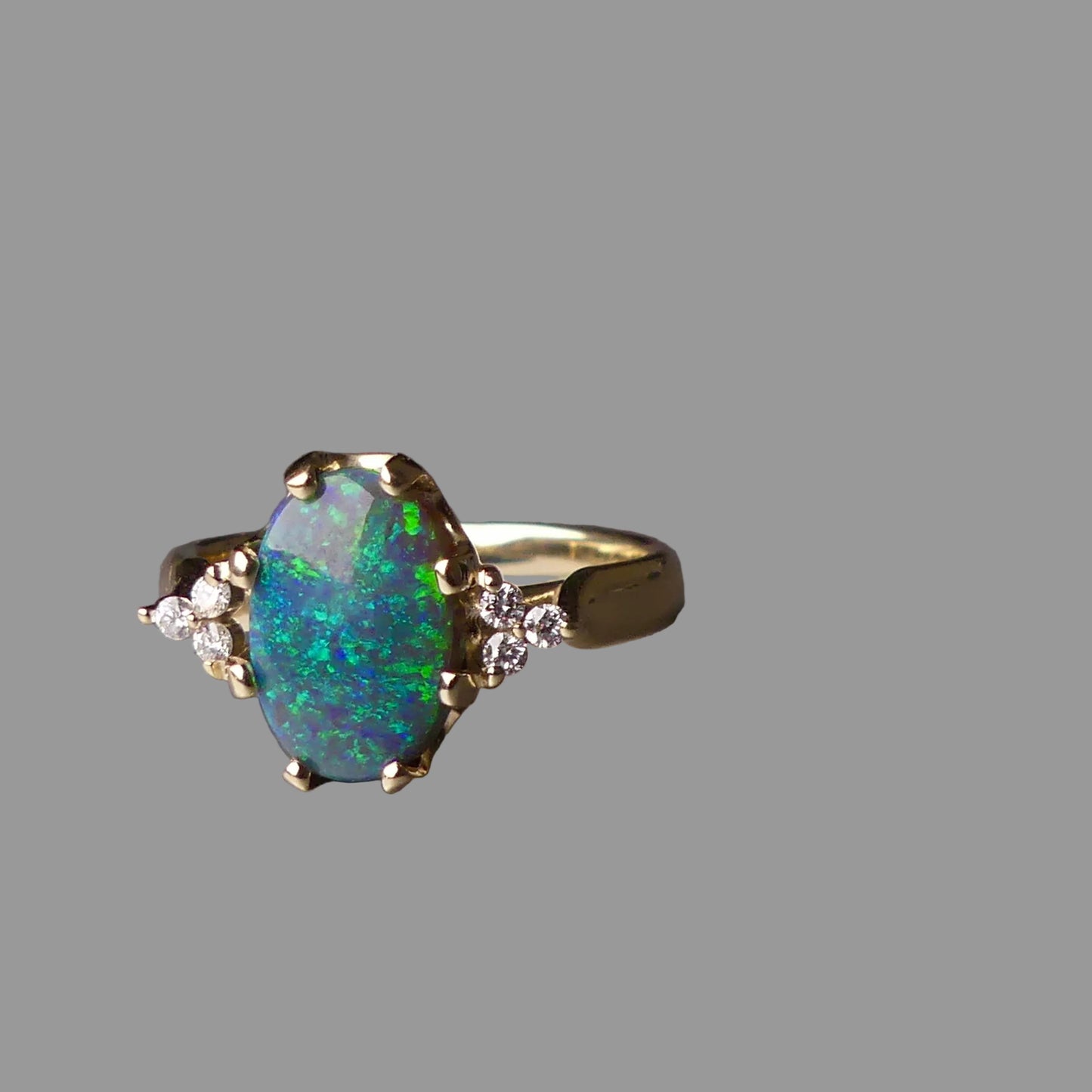 Gold ring with a large opal stone on a gray background