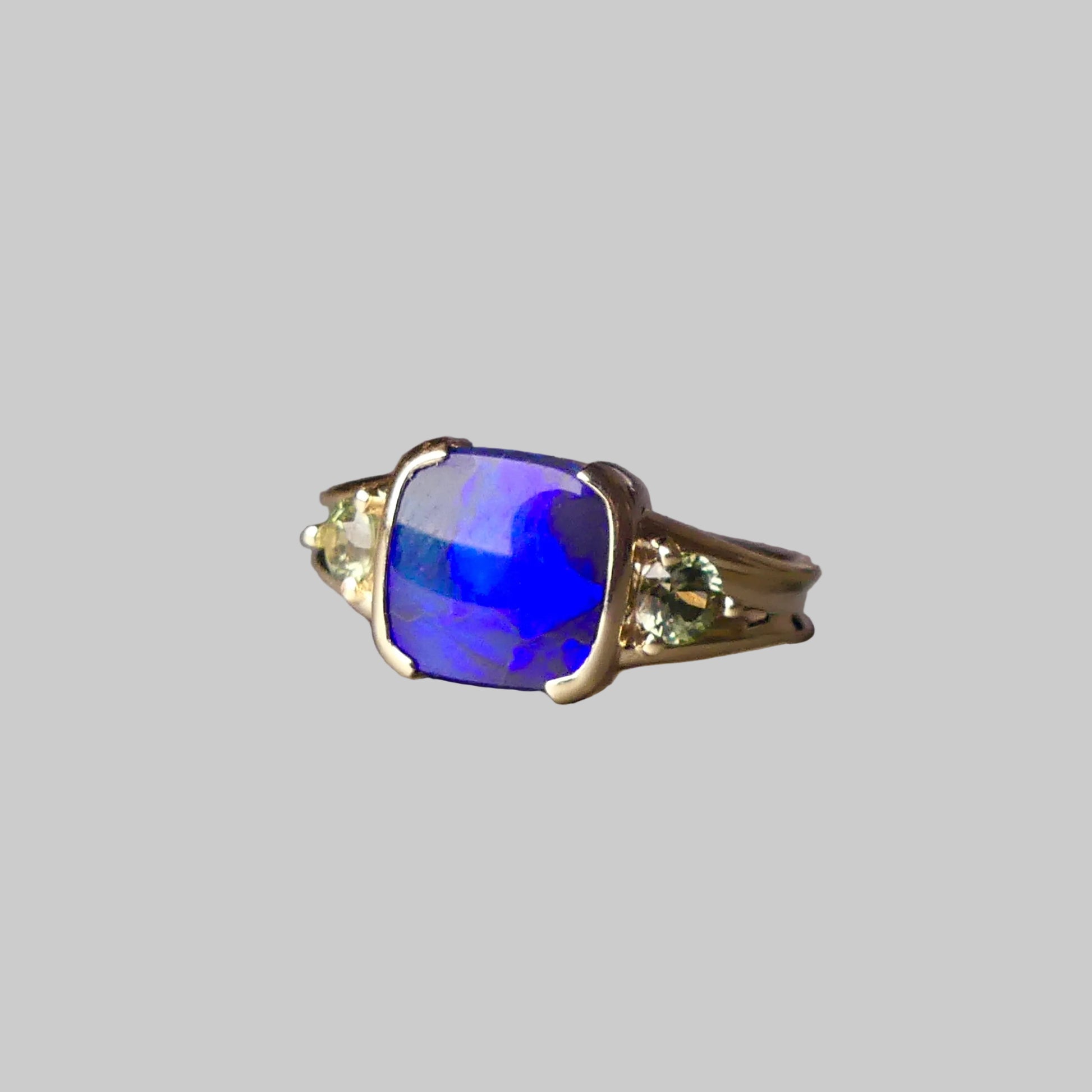 Ring with a blue gemstone on a gray surface