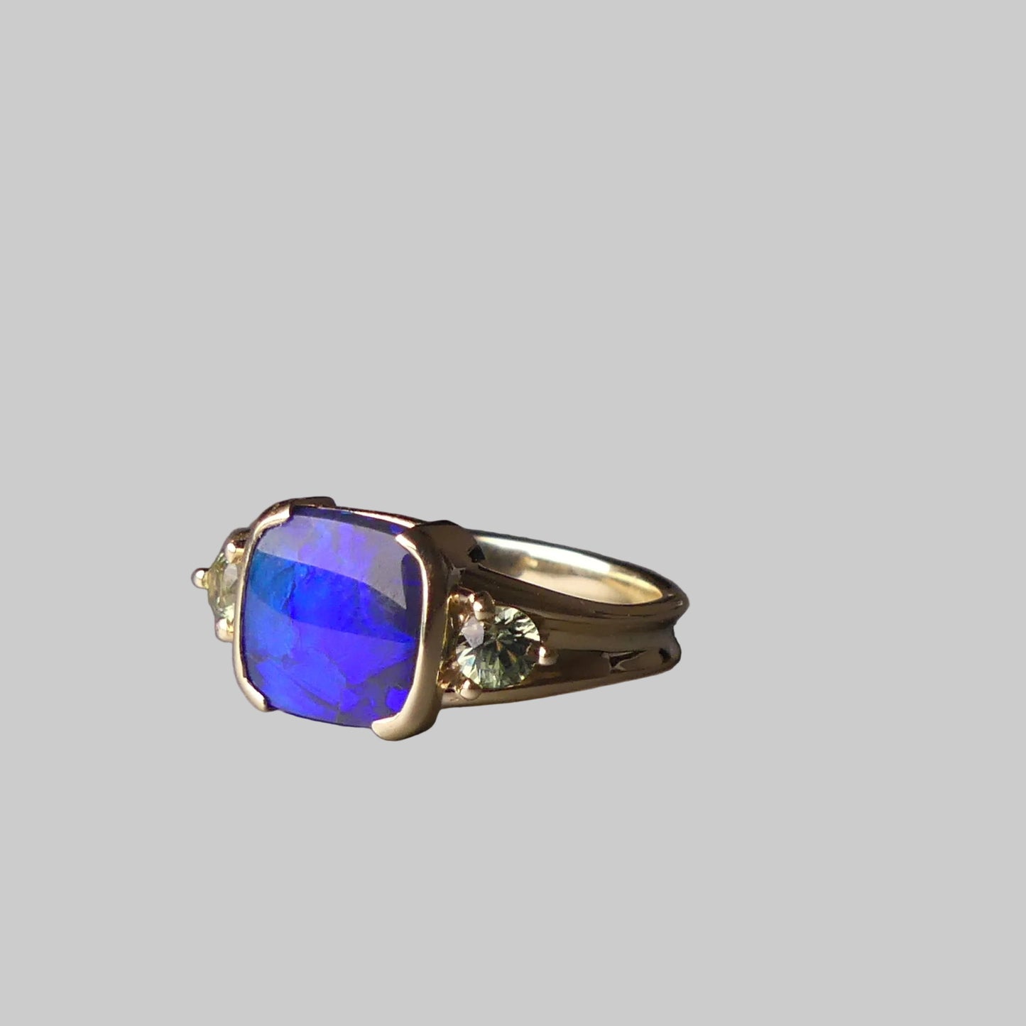 Ring with a blue gemstone on a gray surface