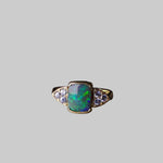 Ring with an opal stone and diamonds on a dark surface
