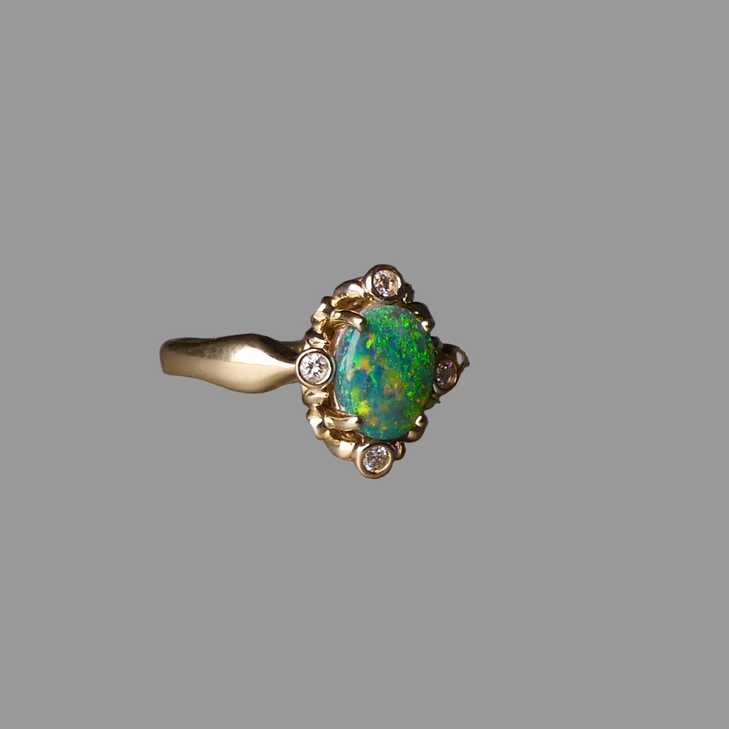 Gold ring with a green gemstone on a dark surface