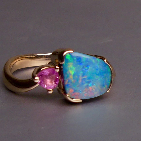 Indulge in luxury with our Elegant 9k Gold Australian Boulder Opal Ring. This opulent piece displays a mesmerizing array of colors, making it a true statement of elegance. Handcrafted with the finest materials, this ring exudes sophistication and exclusivity. Elevate your style and add a touch of opulence to any outfit.

Opal- 2ct Australian Boulder Opal

Origin- Queensland Australia

Setting- 9k Gold Bezel Set

Accent Stone- Pink Tourmaline

Size- 7 1/2