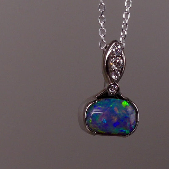 This exquisite pendant features a rare Australian Boulder Opal set in 18k white gold, expertly crafted to highlight the opal’s vibrant play of colors. Accented with natural diamonds, this statement piece that combines exceptional craftsmanship with the distinctive allure of genuine opal.