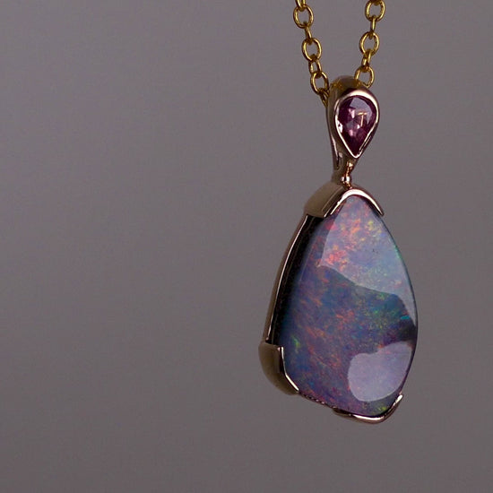 Add a touch of elegance to your jewelry collection with this stunning 9k gold Australian boulder opal pendant. The mesmerizing colors of the opal create a unique and beautiful piece that will surely turn heads. Perfect for everyday wear or special occasions, this pendant is a must-have for any opal lover. A timeless accessory that will elevate any outfit effortlessly.

Opal- 6.75ct Australian Boulder Opal

Origin- Queensland Australia

Setting- 9k Gold Bezel Set

Accent Stone- Pink Sapphire

