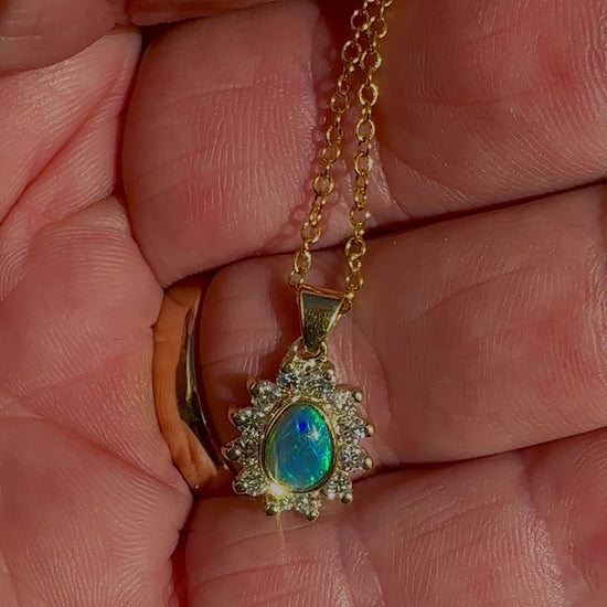 Experience the captivating allure of this handcrafted 18K Yellow Gold Opal &amp; Diamond Halo Pendant. With a striking Lightning Ridge opal showcasing a rare and sought-after script pattern consisting of blue, green, and gold tones, complemented by radiant diamonds, this necklace is a sophisticated and essential piece for any collection.

Origin- Lightning Ridge Australia

Opal Weight- 1ct Australian Lightning Ridge Semi Black Opal

Setting- 18k Yellow Gold Bezel set, claw set Diamond Halo