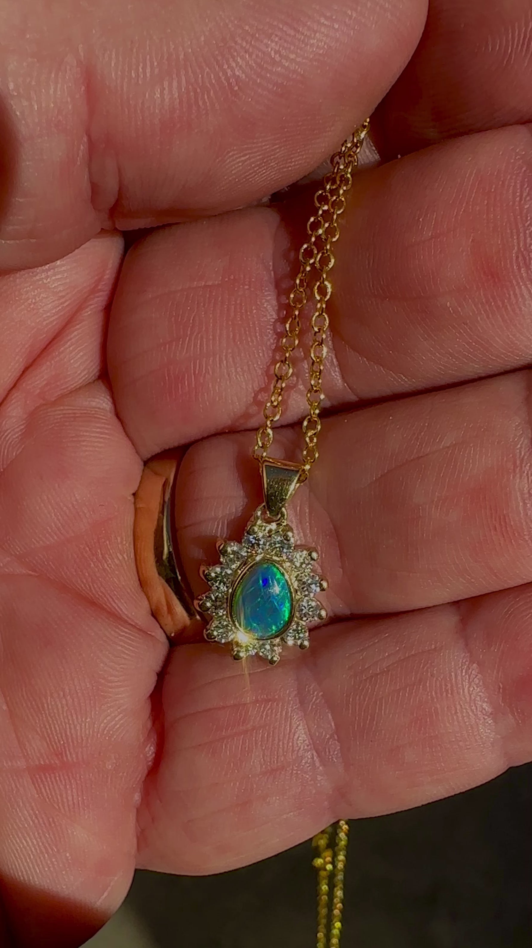 Experience the captivating allure of this handcrafted 18K Yellow Gold Opal &amp; Diamond Halo Pendant. With a striking Lightning Ridge opal showcasing a rare and sought-after script pattern consisting of blue, green, and gold tones, complemented by radiant diamonds, this necklace is a sophisticated and essential piece for any collection.

Origin- Lightning Ridge Australia

Opal Weight- 1ct Australian Lightning Ridge Semi Black Opal

Setting- 18k Yellow Gold Bezel set, claw set Diamond Halo