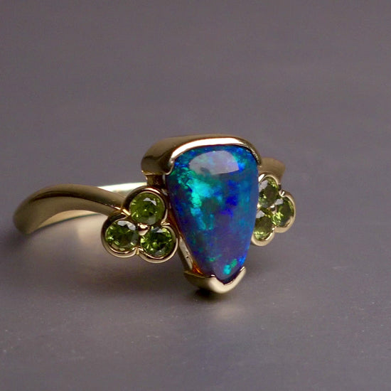 Indulge in timeless elegance with our 14k Australian Black Opal Ring. Crafted with a stunning black opal, this ring showcases mesmerizing blue and green colors. Each piece is unique, making it the perfect addition to any jewelry collection. Elevate your style with this timeless and luxurious ring.

Opal- 1.6ct Australian Black Opal

Origin-Lightning Ridge Australia

Setting- 14k Yellow Gold Bezel Set

Accent Stones- Forrest Green Sapphires

Size- 7 1/4 us
